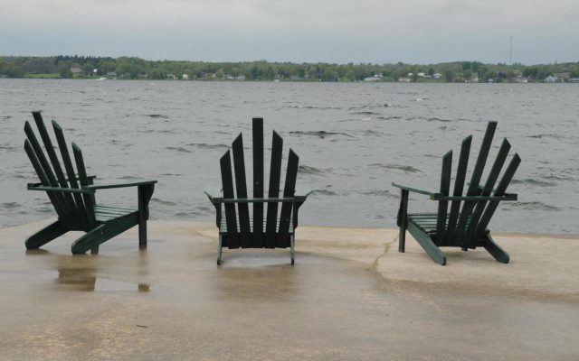 three chairs on concrete dock looking over the St. Lawrence River